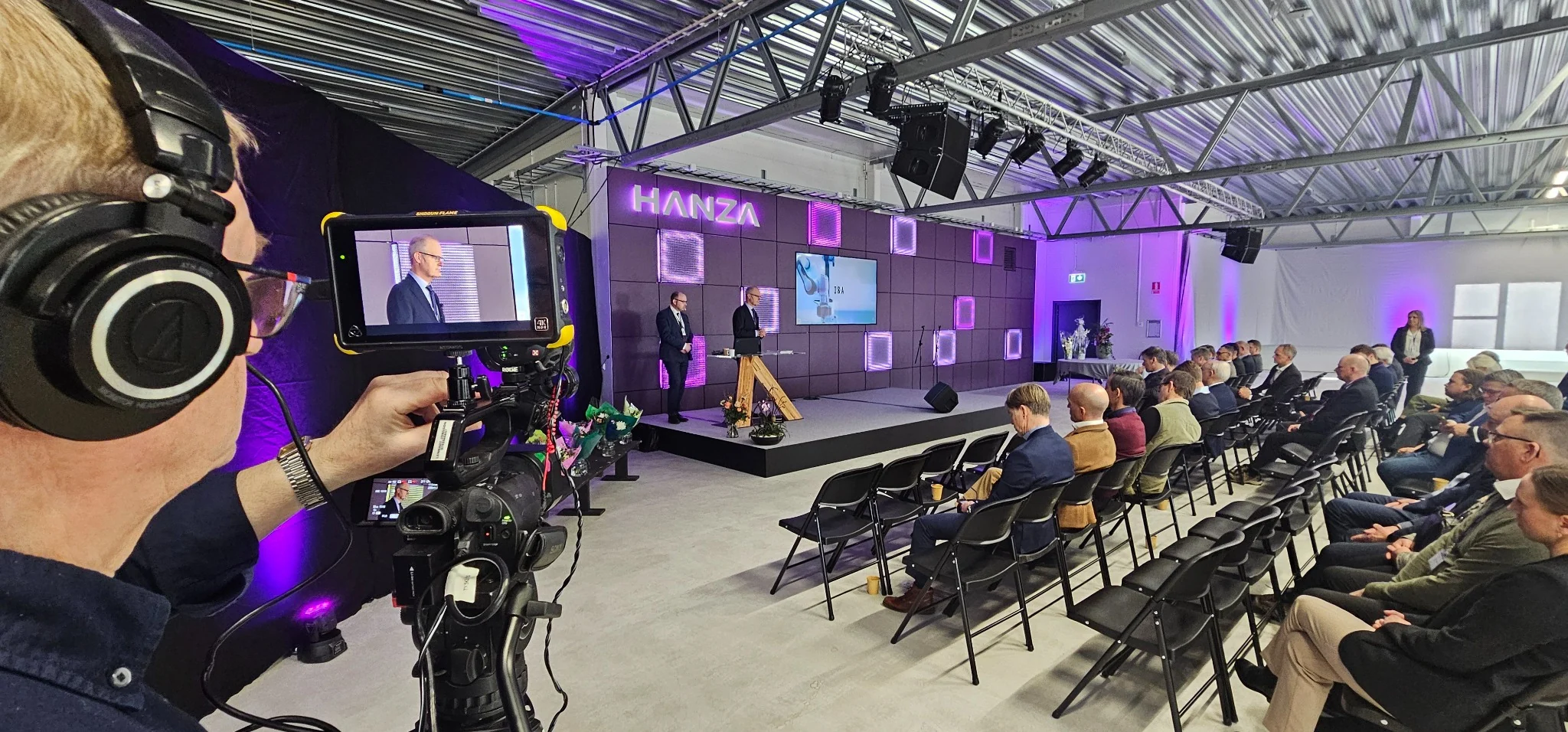 Konferensproduktion med kamera, scen och stor presentationsbild