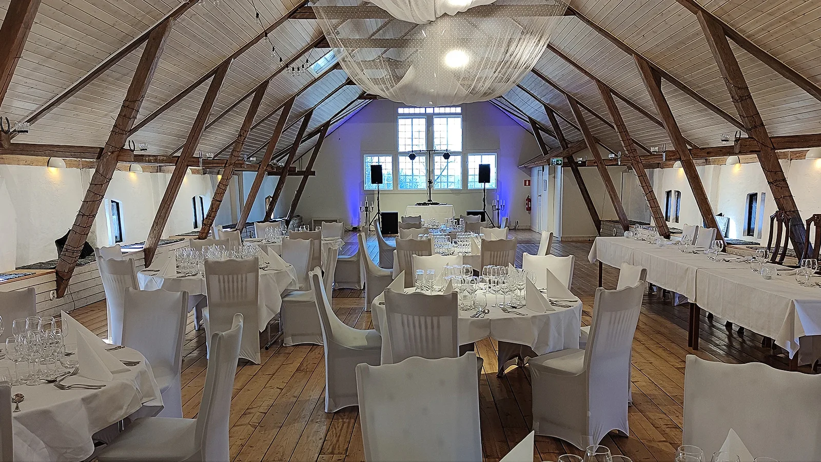 Ljus lada med dukade bord och teknik för bröllop eller bygdegårdsfest