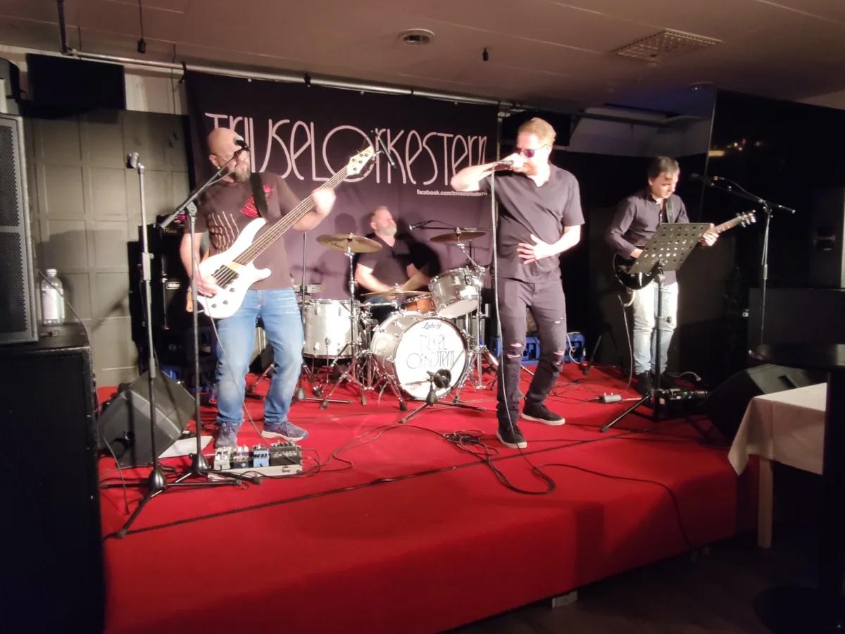 Liveband på mindre scen med ljudsystem och publik nära